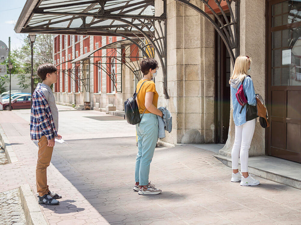 A line of people practicing social distancing at a venue