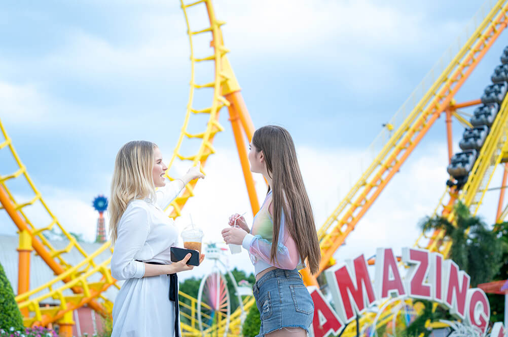 A mother and daughter are talking at a theme park
